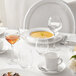 A white table set with Chef & Sommelier white bone china bowls, plates, and glasses.