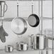 A metal rack with Vigor stainless steel cookware on it.