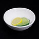 A white Elite Global Solutions melamine bowl with a lime and lemon slices in it.