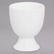 A Chef & Sommelier white bone china egg cup with a base on a gray surface.