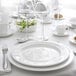 A white table set with Chef & Sommelier white bone china plates and wine glasses.