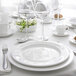 A table set with white Chef & Sommelier Infinity bone china plates and wine glasses.