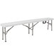 A Flash Furniture white plastic folding bench with metal legs on a white table.
