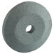 A circular gray sharpening stone with a hole in the center.