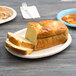 An ivory oval paper platter with a loaf of sliced bread on it.