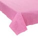 A Creative Converting Candy Pink tablecloth on a table with a white table.