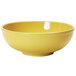 A yellow Tuxton China bowl on a white surface.