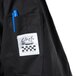 A close up of a Chef Revival Cuisinier black chef coat pocket with a blue pen inside.