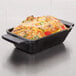 An American Metalcraft pre-seasoned mini cast iron rectangular casserole dish with food in it.