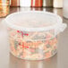 A translucent plastic Cambro food storage container with pasta in it.