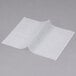 Durable Packaging white interfolded deli wrap paper on a gray surface.