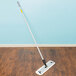 A Unger mop handle in use on a wood floor.