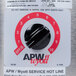 A metal label on a black APW Wyott round cooker/warmer with black and red knobs.