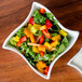 A close up of a vegetable salad in a white American Metalcraft Prestige wave bowl.