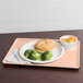 A Cambro light peach dietary tray with a plate of food, a sandwich, and broccoli on it with a fork.