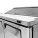 A Turbo Air stainless steel 2 door refrigerated sandwich prep table with a white top on a counter.
