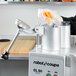 A Robot Coupe CL50 food processor on a counter with food.