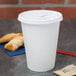 A Solo white plastic tab lid on a white paper hot cup with a red straw.