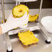 A person in gloves using a Nemco Easy Pineapple Corer to cut a pineapple.