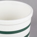 A green and white striped CAC China jar with a lid.