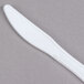 A close-up of a Dart white plastic knife.