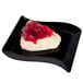A piece of cheesecake with cherry topping on a black Fineline plastic dessert plate.