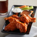 A plate of Frank's RedHot buffalo wings with ranch and celery dipping sauces.