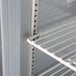 A close up of the interior shelf of a Beverage-Air worktop refrigerator with a metal rack.