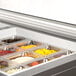 A Beverage-Air refrigerated sandwich prep table with glass lids containing trays of food on a counter.