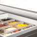 A Beverage-Air refrigerated sandwich prep table with glass lids holding trays of food.