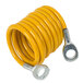 A yellow coiled gas hose with metal fittings and a restraining cable.