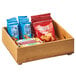 A Cal-Mil Madera wood stacking box filled with a variety of snacks on a table.
