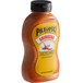 A Pilsudski Sriracha Mustard squeeze bottle with a yellow label.