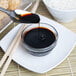 A spoon pouring La Choy soy sauce into a bowl of rice.