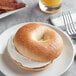A plain New York style bagel with cream cheese on a plate.