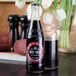 A Boylan Diet Cane Cola bottle on a table next to a glass of liquid.