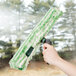 A hand holding a Unger Ninja T-Bar window washer handle with a green and white mop.