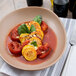 A bowl of Cento Italian whole peeled plum tomatoes and squash on a table.