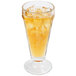A Libbey soda glass filled with yellow liquid and ice.