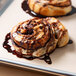 Baker's Mark PanPal Non-Stick Pan Liner unrolled on a counter with chocolate and caramel swirl cinnamon rolls.