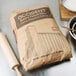 A bag of Ardent Mills Occident Bakers Short Patent flour next to a rolling pin on a counter.