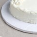 A white round cake on a white Enjay cake drum.