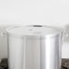 A Vollrath Wear-Ever aluminum pot cover on a large silver pot on a stove.