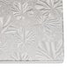 A white fabric with a pattern on a white surface with a silver Enjay quarter sheet cake board with leaves on it.