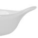 A white china shirred egg dish with a long handle.