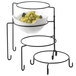 A Tablecraft black metal 4 tier display stand with a bowl of grapes.
