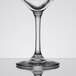 A close-up of a Libbey chalice wine glass filled with wine on a table.