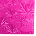 A pink surface with floral designs on a pink Enjay cake board.