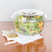 A Dart clear plastic bowl filled with salad and a white plastic fork.