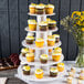 A white Enjay 5-tier cupcake stand with cupcakes on it.
